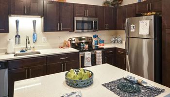 a kitchen with dark cabinets and white countertops